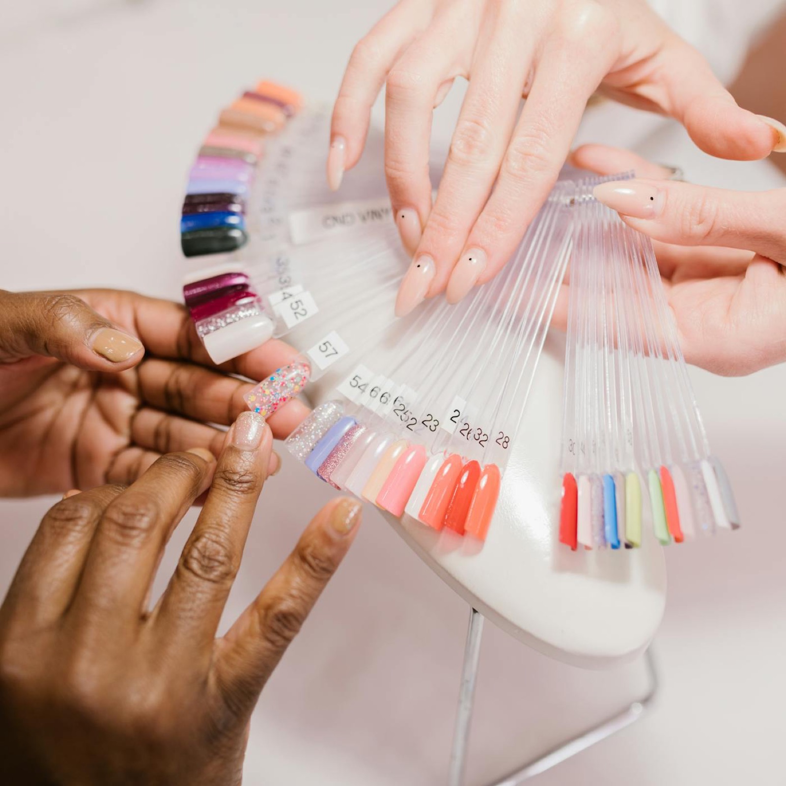 Clients comparing nail color swatches during a manicure consultation